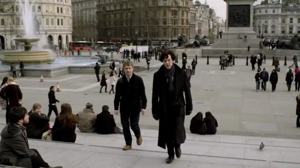 Sherlock Holmes London Walking Tour: Free Self-Guided Literary Route + Downloadable Map 11 Sherlock and John from the BBC Sherlock tv series walking through Trafalgar Square during a scene in the show set in London, England, United Kingdom.