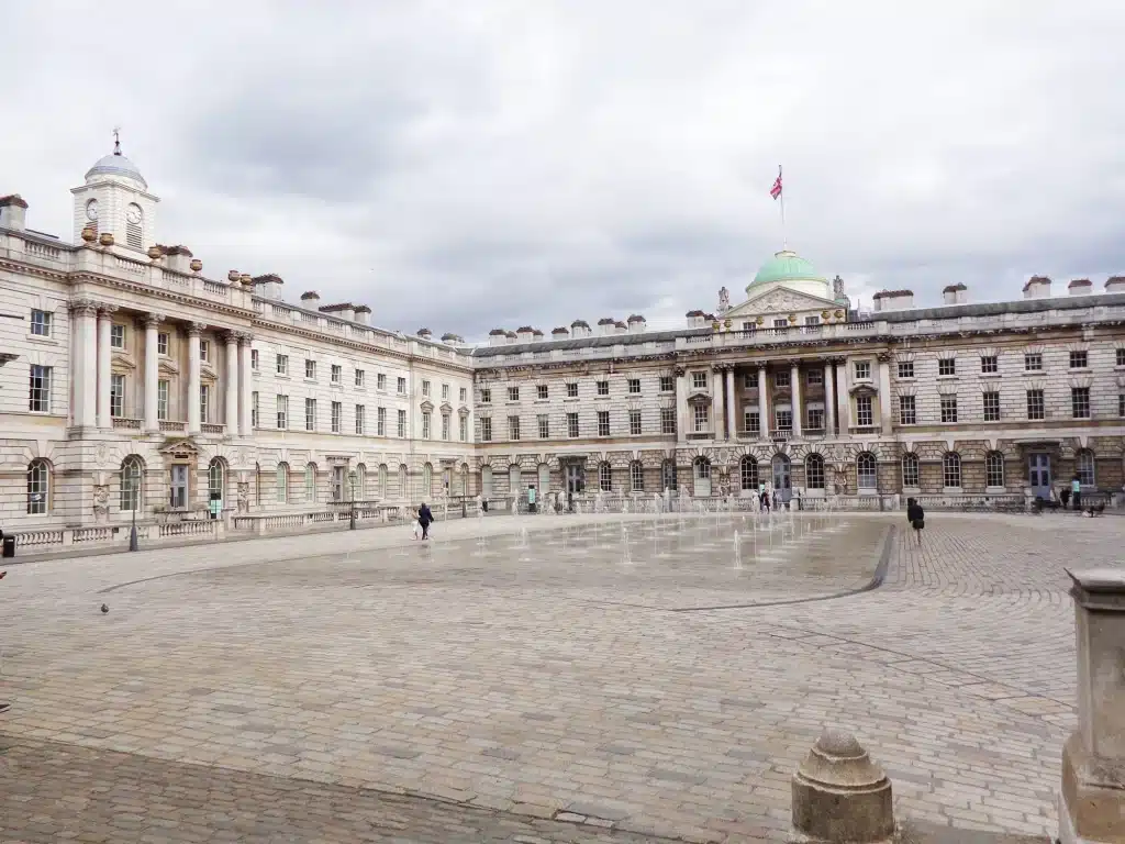 London 2-Day Itinerary: The Best Attractions for First-Timers + Downloadable Map 46 Grand courtyard at Somerset House in London, England, United Kingdom, featuring classical architecture with arched windows and a large open plaza under a cloudy sky.