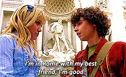 75 Movies Set in European Destinations to Inspire Your Next Trip 65 Animated GIF scene from The Lizzie McGuire Movie showing Lizzie and Gordo standing in front of the Trevi Fountain in Rome, Italy. Lizzie is smiling slightly as Gordo looks at her, with the subtitle reading, “I’m in Rome with my best friend, I’m good.”