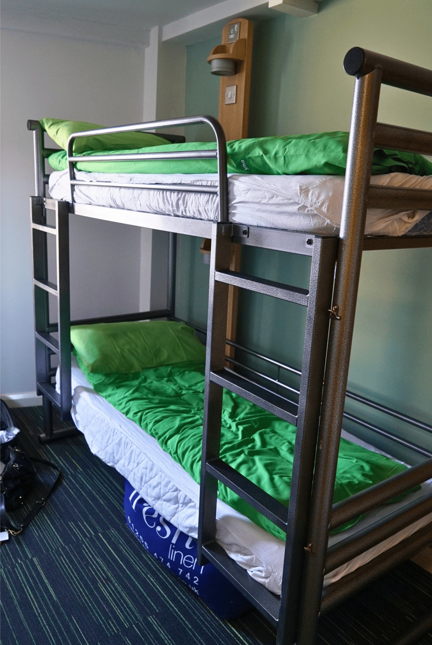 Reviewing Astor Oxford Street: Is It a Safe Hostel to Stay at in Soho, London? 5 Interior of a dorm room at YHA Oxford Street hostel in Soho, London, England, United Kingdom, featuring metal bunk beds with green bedding.