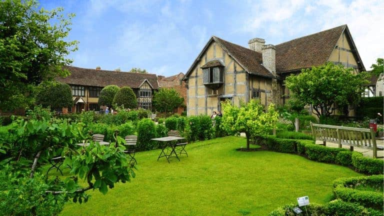 A lush garden at Shakespeare’s Birthplace in Stratford‑upon‑Avon, England, United Kingdom, with neatly kept pathways and heritage‑style half‑timbered houses framing the scene.