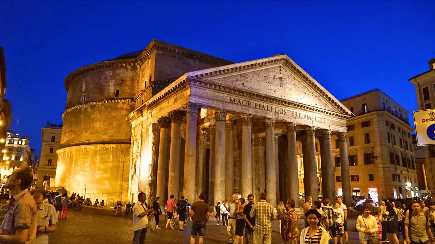 The glowing facade of the Pantheon in Rome, Italy, at night, lit by warm flood‑lights that highlight the grand portico of Corinthian columns against a deep evening sky.