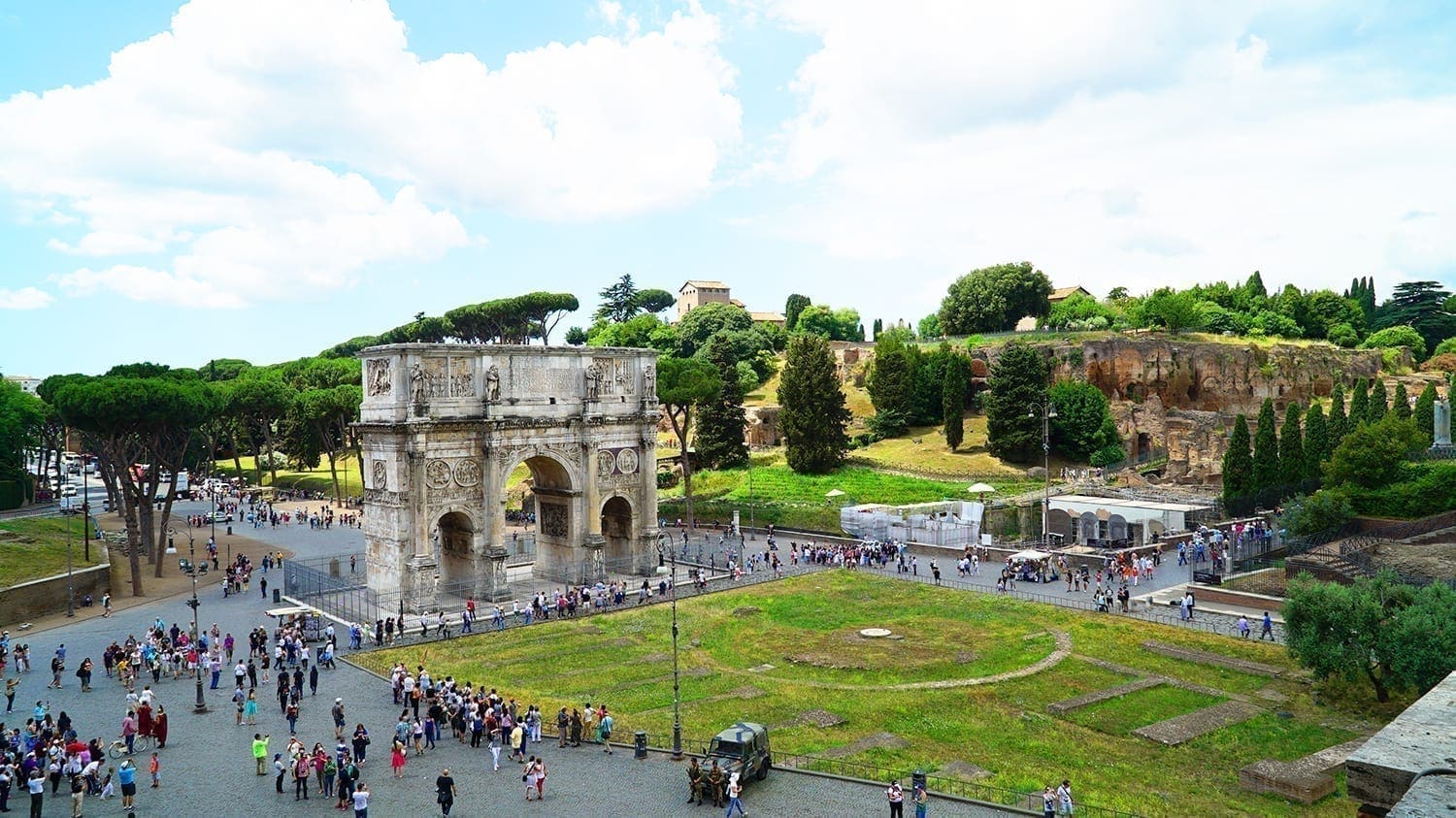 3 Big Mistakes I Made While Visiting the Colosseum in Rome 16 View from the Colosseum overlooking the Roman Forum and Palatine Hill, showing ancient columns, ruins, and pathways surrounded by greenery and historic buildings, including the Triumphal Arch of Constantine.