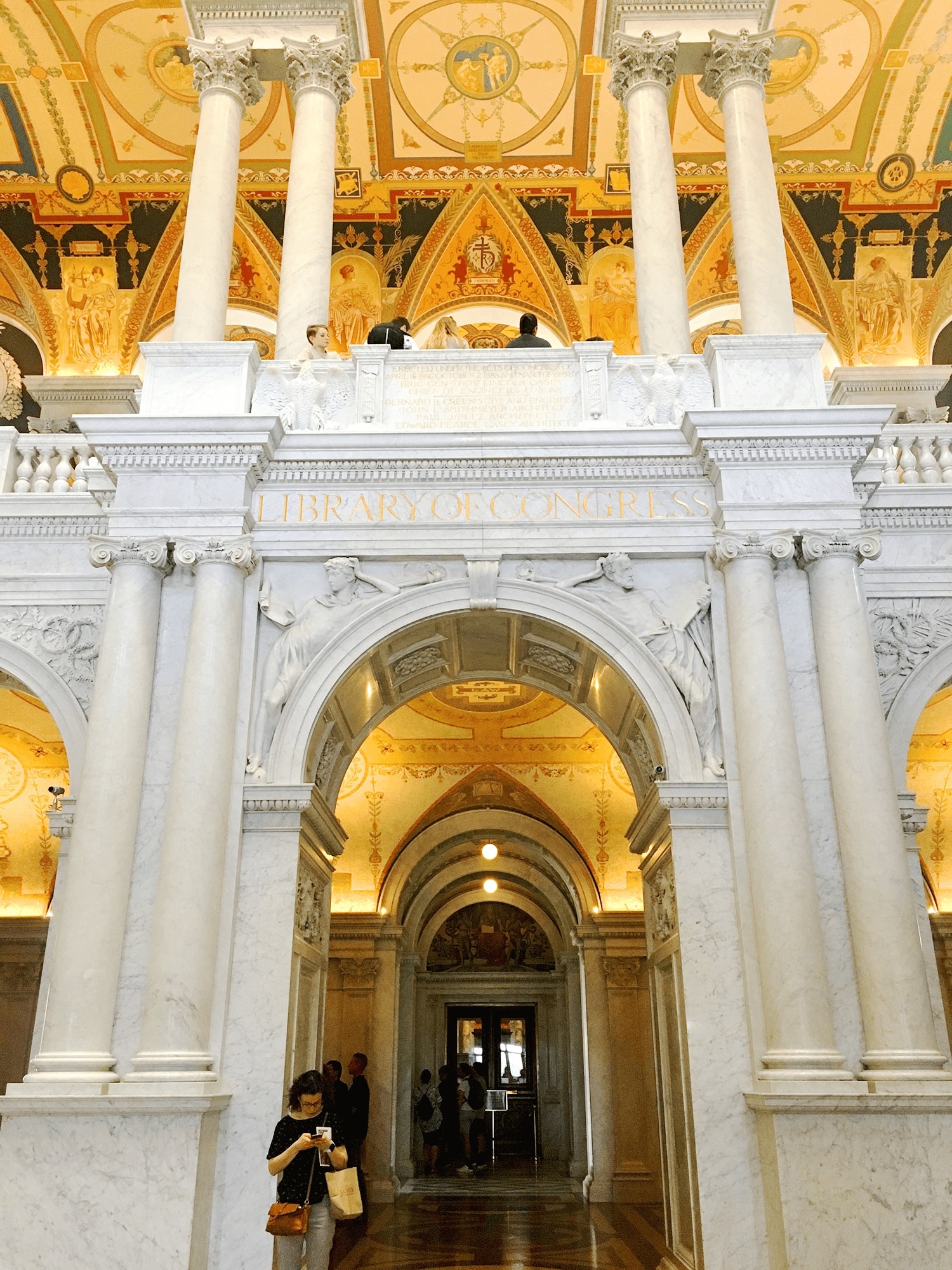 6-Day United States History Road Trip Itinerary Inspired by Hamilton the Musical 43 People visiting the interior of the Library of Congress, showcasing a grand domed ceiling, ornate columns, arched doorways, and marble statues in Washington DC.