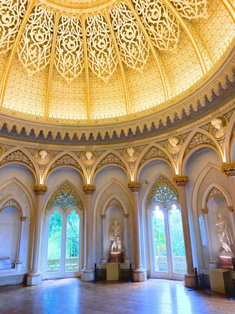 22 of the Best Things to Do in Lisbon, Portugal (My Budget-Friendly Picks) 39 Ornate interior view of the Music Room dome in the Monserrate Palace in Sintra Portugal featuring intricate plasterwork floral motifs and geometric patterns illuminated by natural light from the central oculus with busts and statues below by arched windows.