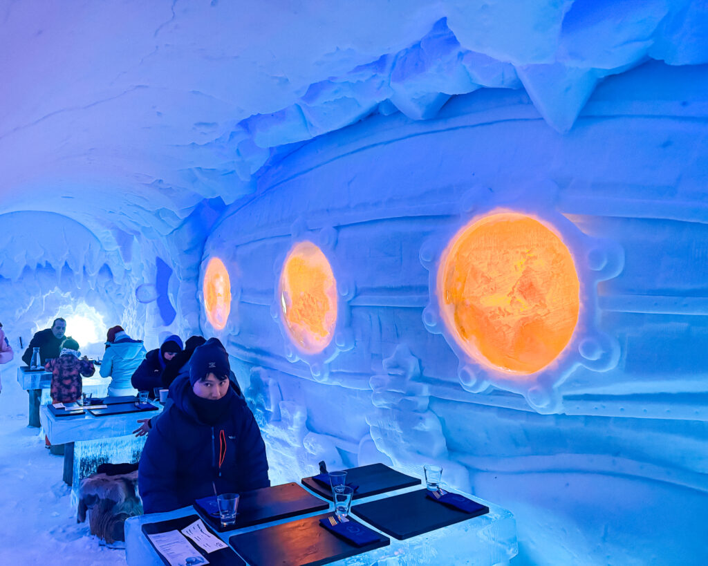 The Best Hotels in Rovaniemi, Finland: Comparing My Glass Igloo Stay with the City Center 36 Unique Arctic SnowHotel Ice Restaurant Blue Sculpture in a Submarine Theme.