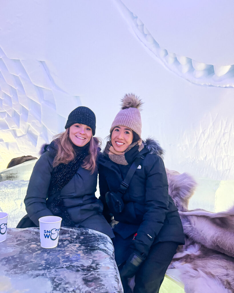 Is Rovaniemi, Finland, Worth Visiting? 19 Reasons You Should Visit in Winter 48 Women enjoying ice bar at Snowman World in Rovaniemi, Finland.