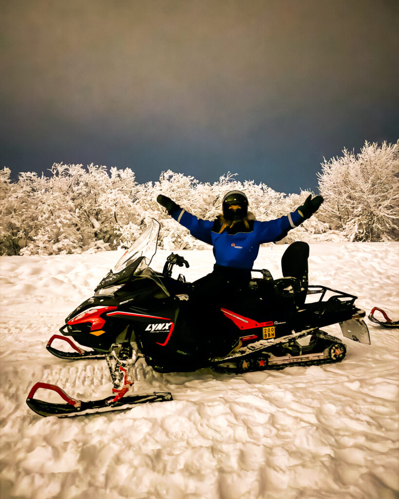 Is Rovaniemi, Finland, Worth Visiting? 19 Reasons You Should Visit in Winter 13 Snowmobiling adventure in Rovaniemi with woman enjoying the snowy landscape.