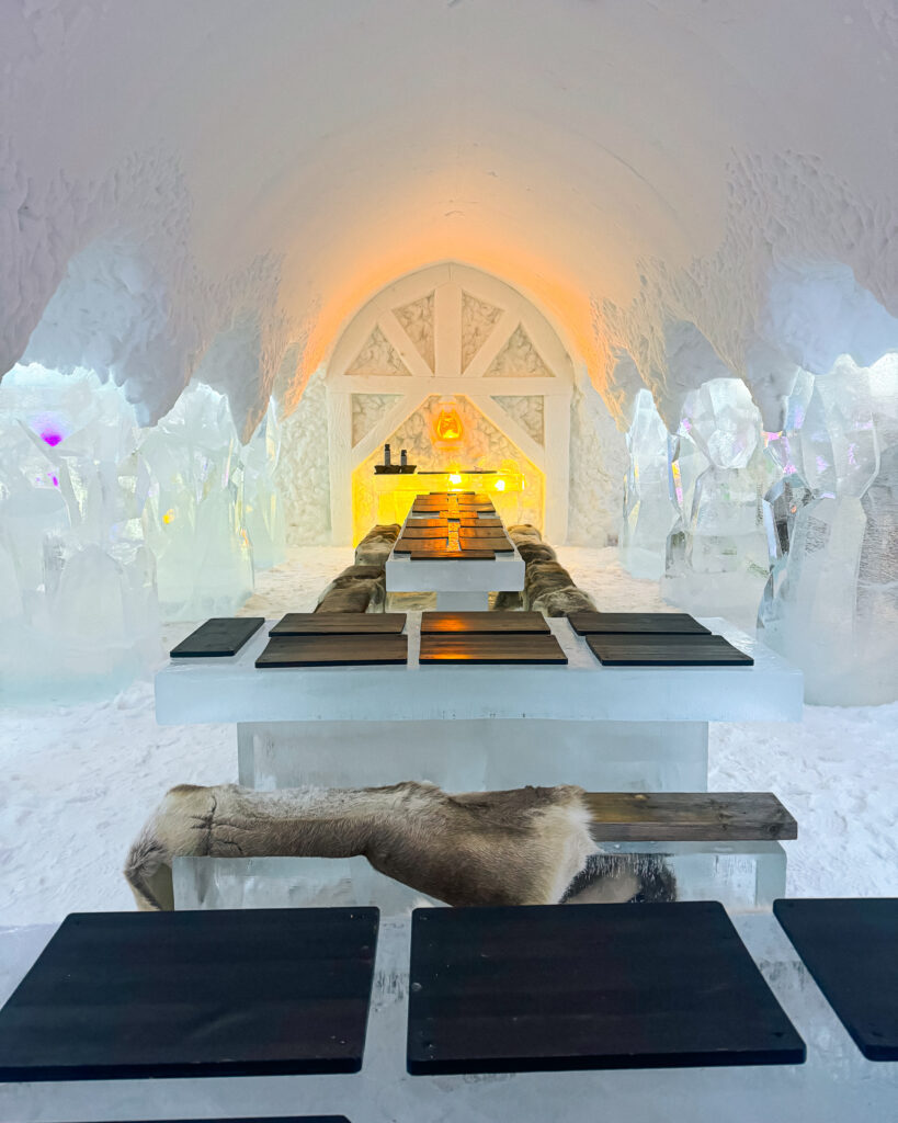 The Best Hotels in Rovaniemi, Finland: Comparing My Glass Igloo Stay with the City Center 37 Arctic SnowHotel yellow mining sculptures in ice restaurant, winter wonderland scene.