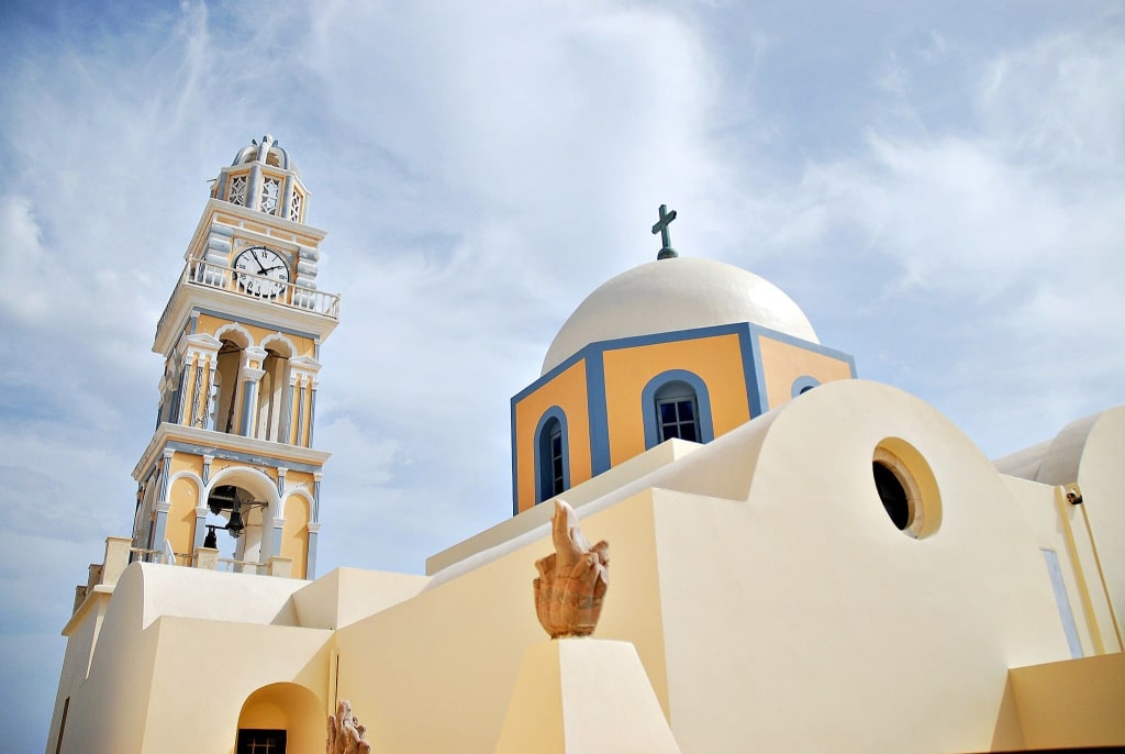 Is Santorini, Greece, Worth Visiting? 14 Pros and Cons for First-Time Travelers 28 Stunning Catholic Cathedral in Fira, Santorini, Greece, featuring blue dome and detailed bell tower.