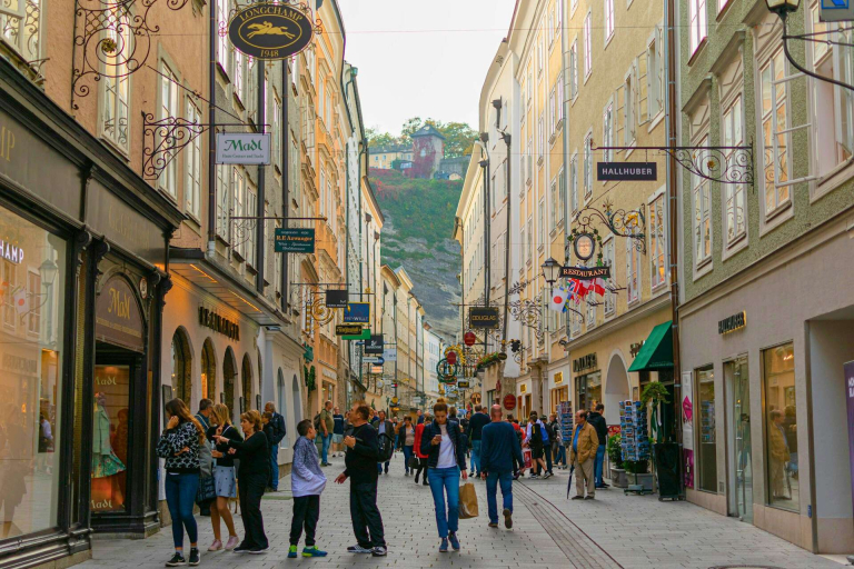 Getreidegasse in Salzburg, Austria, a narrow pedestrian street lined with historic buildings, wrought-iron shop signs, and boutiques.