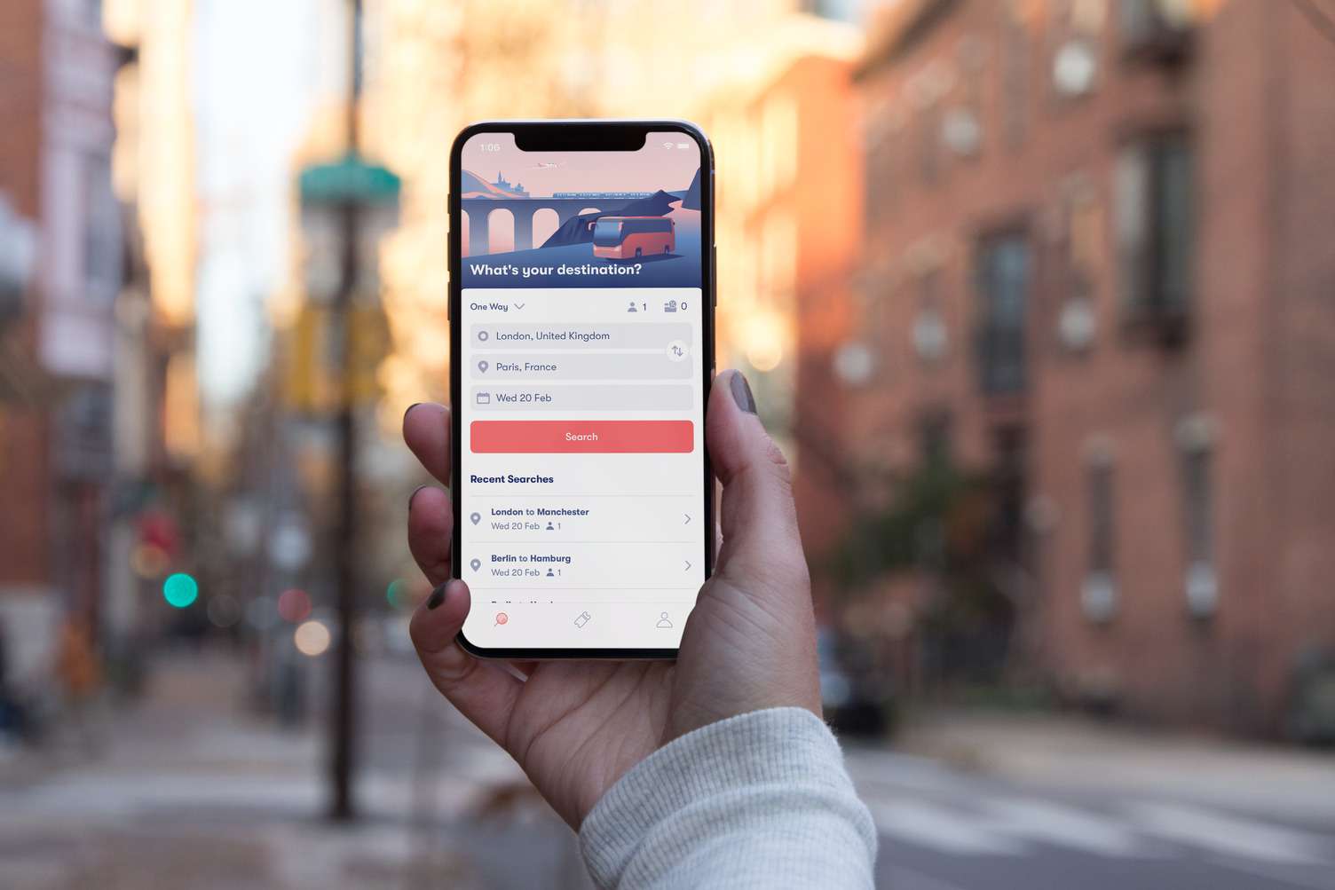 A hand holding a smartphone displaying the Omio travel app, with options for trains, buses, and flights to Paris, France.