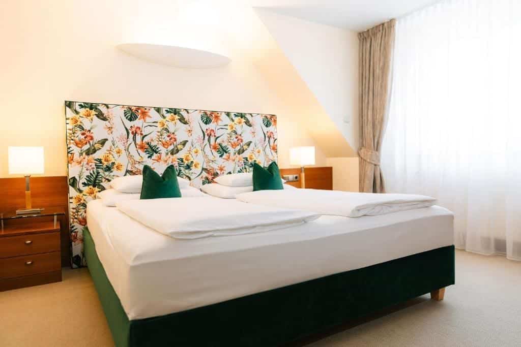 Where to Stay in Vienna, Austria: My Favorite Areas + Best Budget Hotels 38 hotel kaiserhof wien attic bedroom floral headboard vienna austria