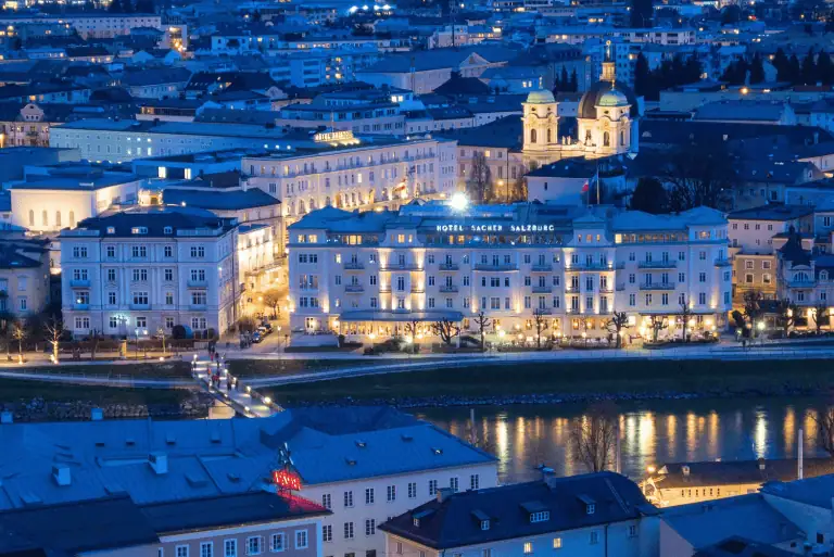 Where to Stay in Salzburg, Austria: My Favorite Area for First-Timers on a Budget 7 Nighttime view of Hotel Sacher illuminated with warm lights, highlighting its historic architecture. A luxurious and central accommodation option when deciding where to stay in Salzburg, Austria.