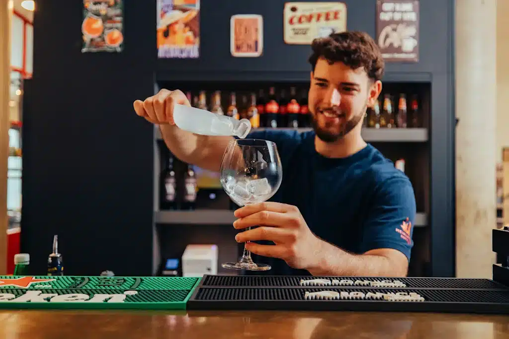 Where to Stay in Vienna, Austria: My Favorite Areas + Best Budget Hotels 49 meininger hotel vienna downtown franz bartender pouring drink vienna austria