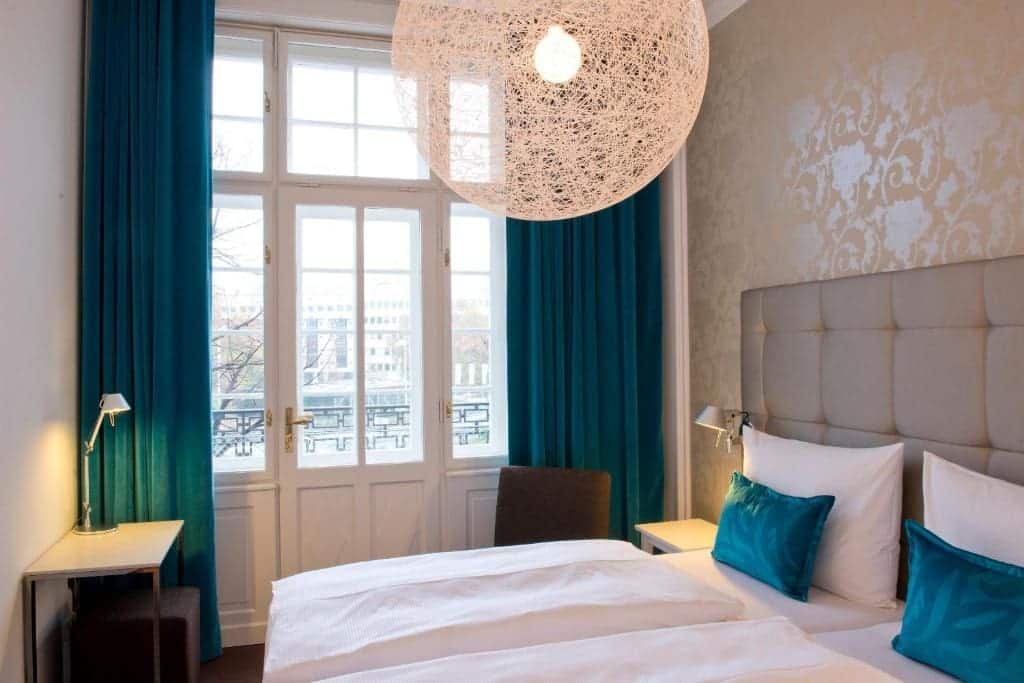 Where to Stay in Vienna, Austria: My Favorite Areas + Best Budget Hotels 34 motel one wien staatsoper twin bedroom teal curtains vienna austria